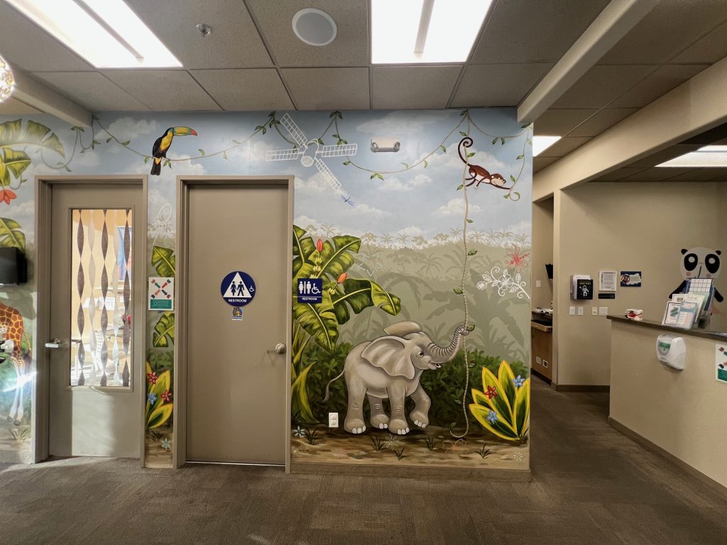 restrooms-pediatric-dentist-kids-care-dental-orthodontics-lodi-ca Entrance to restrooms with jungle themed wallpaper inside Kids Care Dental & Orthodontics in Lodi, CA
