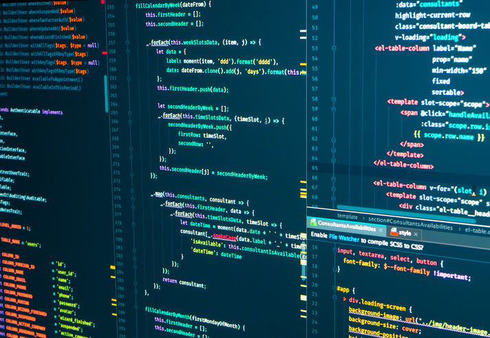 Lines of website code on dark monitors, representing the PHP security update for WordPress sites