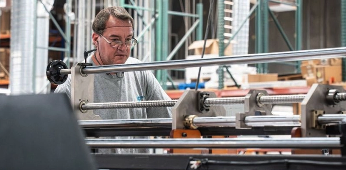 A Pak-Pro packaging supplier team member operating folding carton equipment on the plant floor.
